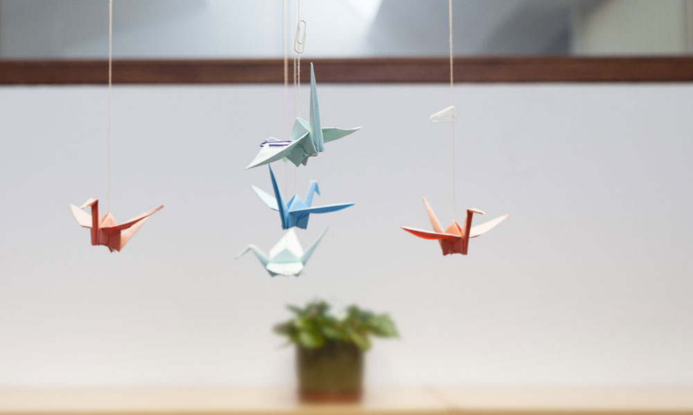 Unhas paxariñas de papel fan un móbil de cores