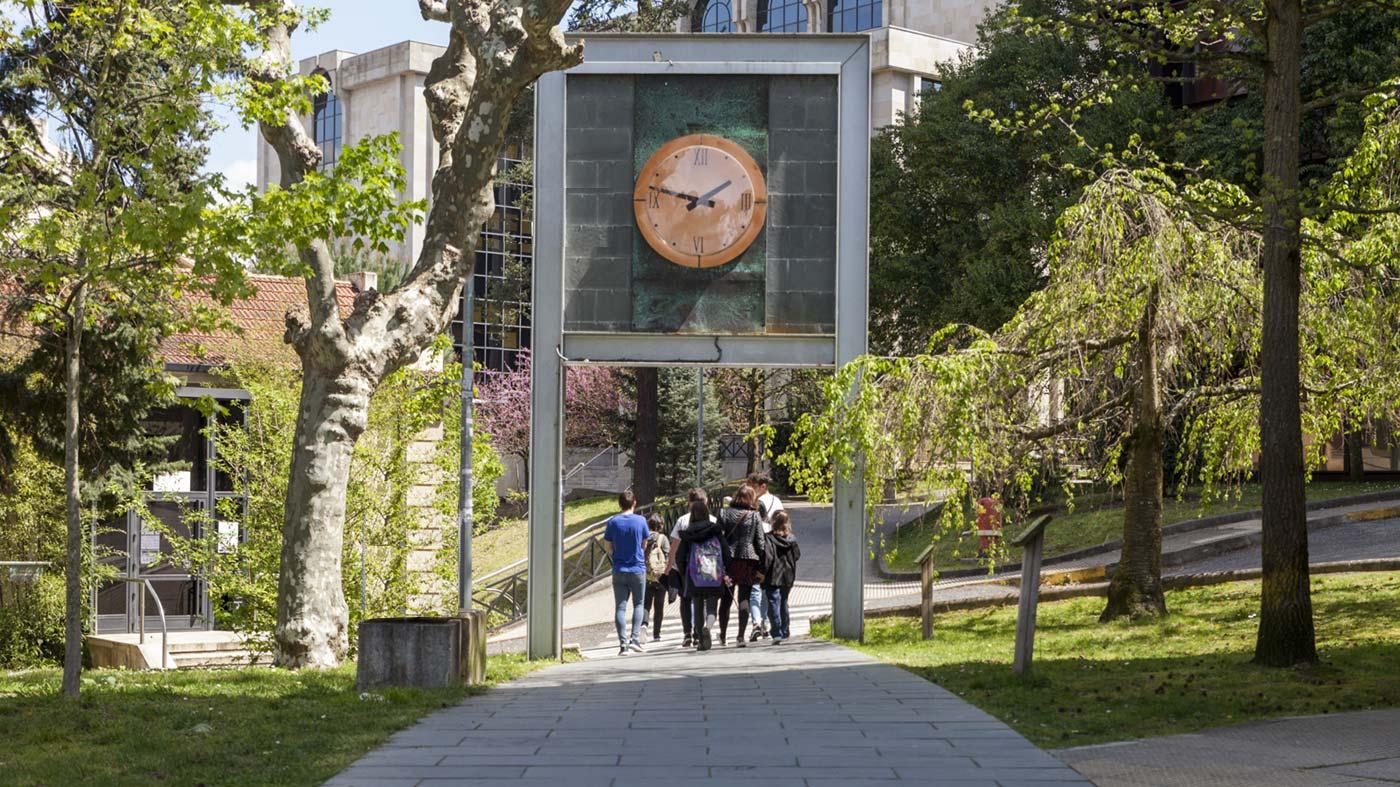 Estudantes pasan por baixo do emblemático reloxio do campus de Ourense